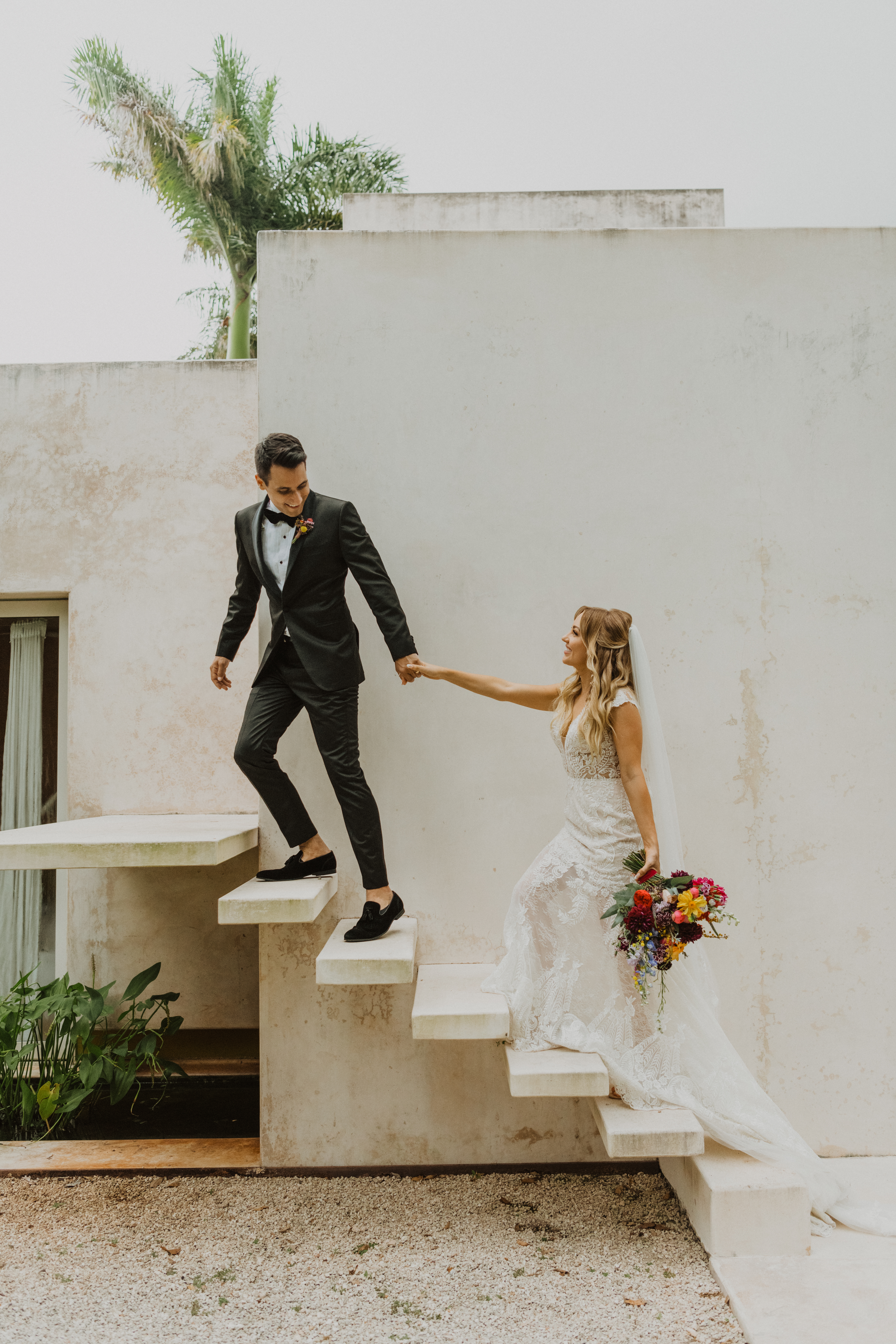 bride and groom walking up steps in Merida, Mexico