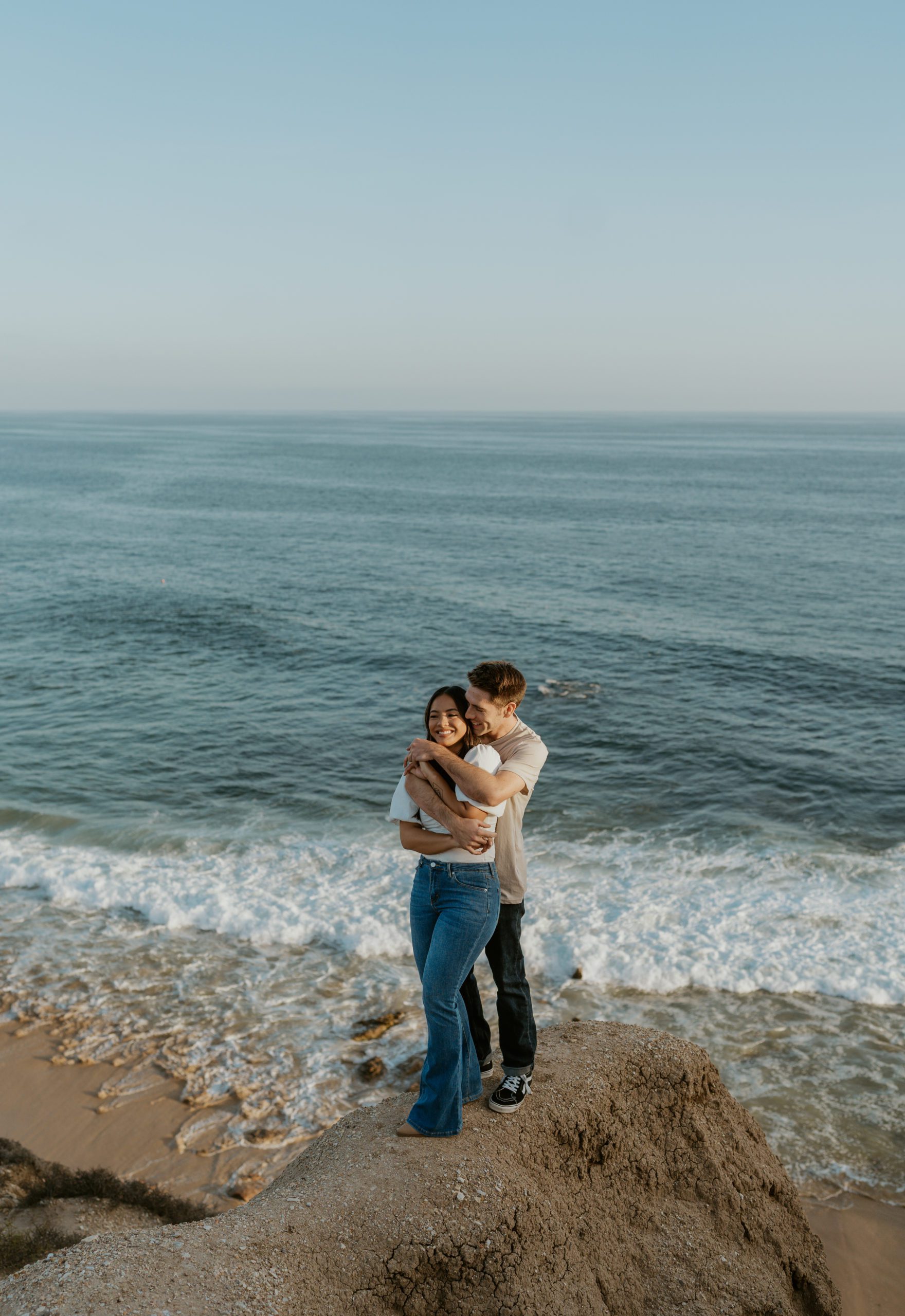 couple posing on rock at crystal cove beach